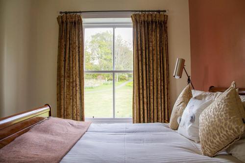
a bedroom with a bed and a window at Loch Melfort Hotel in Ardfern
