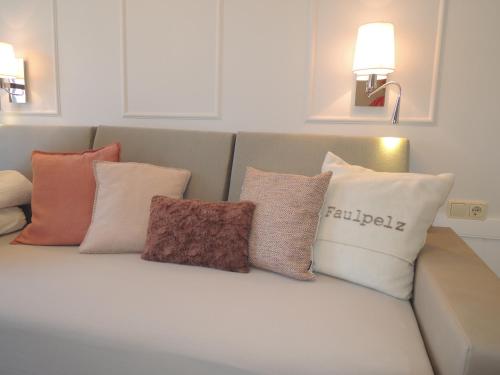 a couch with several pillows sitting on it at Gästehaus Muhl in Strukkamp auf Fehmarn