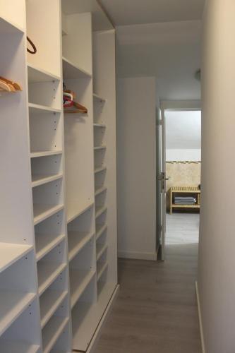 a walk in closet with white walls and shelves at Cactus Home Penthouse in La Garita