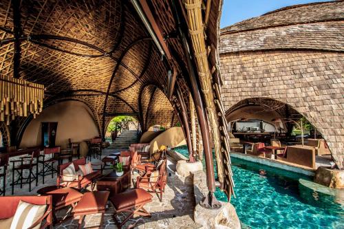 a resort with a swimming pool and tables and chairs at Wild Coast Tented Lodge - Relais and Chateaux - All Inclusive in Yala