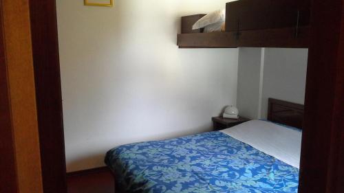 a bedroom with a bed with a blue and white blanket at Monterotta 18 in Sestriere