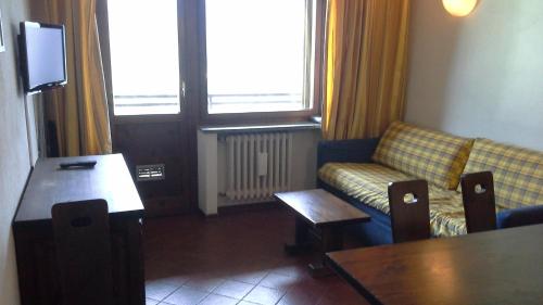 salon z kanapą i stołem w obiekcie Monterotta 18 w mieście Sestriere