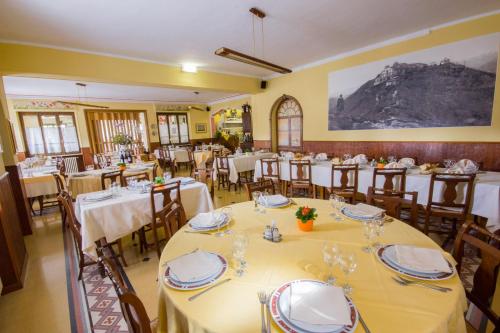 a dining room with tables and chairs in a restaurant at Ristorante Buasca in Cuorgnè