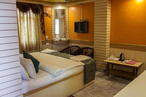 a room with a bed with a mirror and a table at Hotel Temple On Ganges in Varanasi
