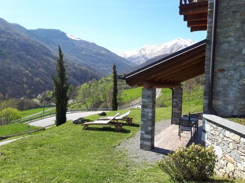 a patio with picnic tables and mountains in the background at Agriturismo Nona Rosa in Gravedona