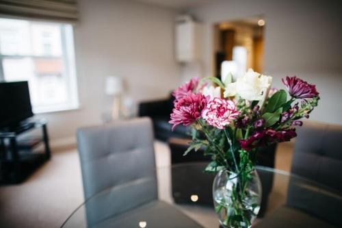 a vase of flowers sitting on a glass table at Waterfront Apartments in Douglas