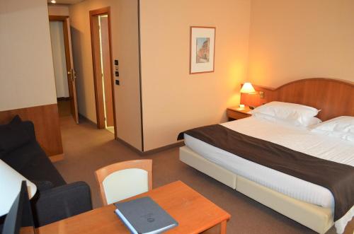 a hotel room with a bed and a table with a laptop at Best Western Park Hotel in Piacenza