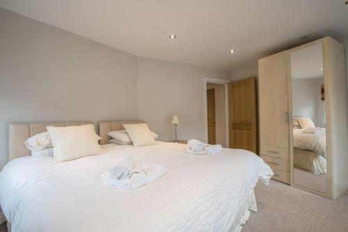 a bedroom with a large white bed with towels on it at Waterfront Apartments in Douglas