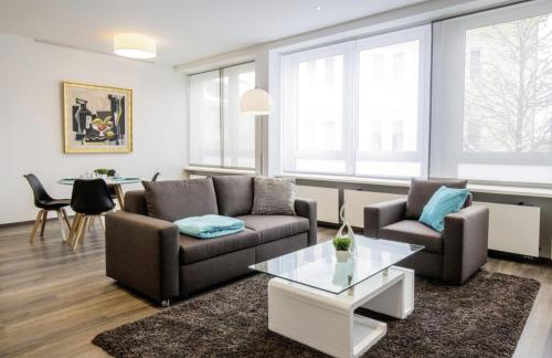 a living room with two couches and a table at Apartments by Intermezzo in Albstadt