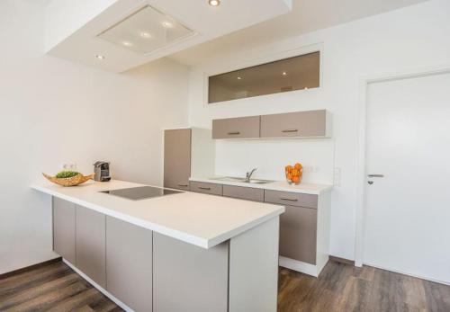 a kitchen with white cabinets and a white counter top at Apartments by Intermezzo in Albstadt