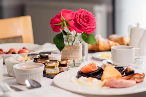 a table with plates of food and a rose in a vase at Highfield Park in Hook