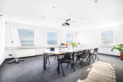 an office with a table and chairs and windows at GT3 Hotel in Honerath
