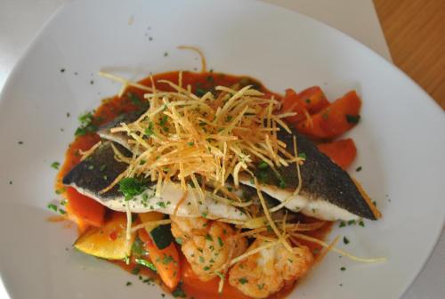 a white plate with a sandwich with cheese and tomatoes at Hotel & Restaurant Dankl in Lofer