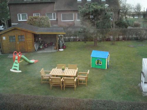 a backyard with a table and chairs and a playground at Ferienwohnung Maren Graf in Neustadt in Holstein