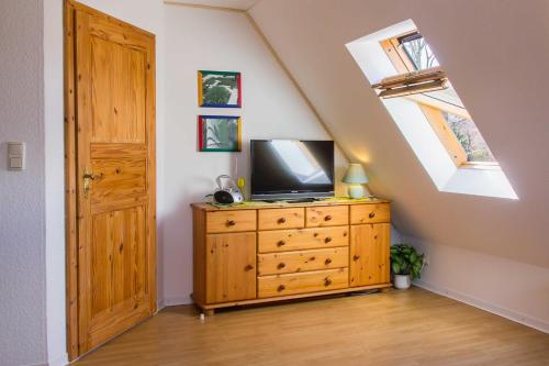 a room with a television on a dresser in a attic at Ferienwohnung Lampe in Neustadt in Holstein