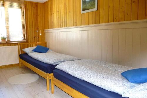 two beds in a room with wood paneling at Hammerfinken-Nest in Wurzbach