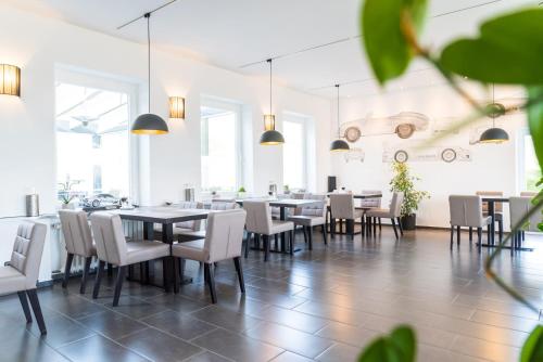 a dining room with tables and white chairs at GT3 Hotel in Honerath