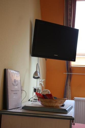 a flat screen tv on top of a desk at Cross-Country-Hotel Hirsch in Sinsheim