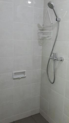 a shower with a shower head in a bathroom at Robert's Condominium in Jakarta