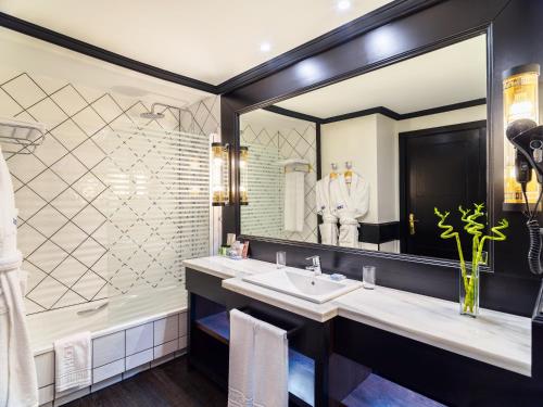 La salle de bains est pourvue d'un lavabo, d'une baignoire et d'un miroir. dans l'établissement H10 Rubicón Palace, à Playa Blanca
