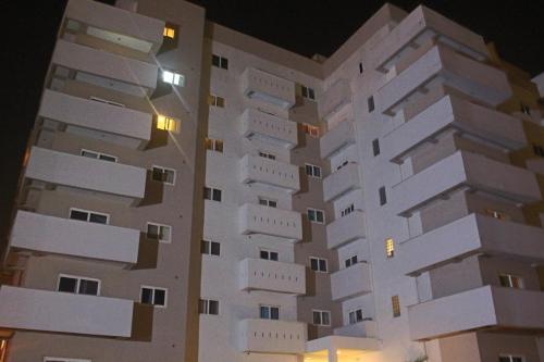 a tall white building with windows at night at Accra Luxury Apartments in Accra