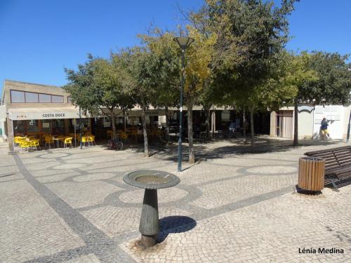 a table in the middle of a courtyard with trees at "A Casa dos Avôs" Suites & Breakfast in Lagos