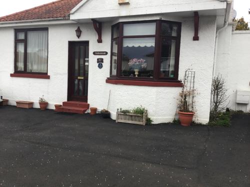 a white house with a window with flowers in it at Ingleneuk Bed and Breakfast in Edinburgh
