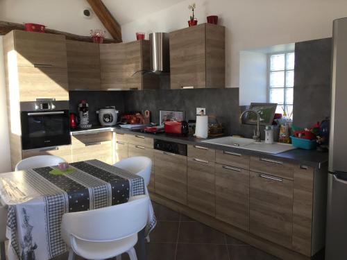 a kitchen with wooden cabinets and a table and a sink at La maison des canards in Romorantin