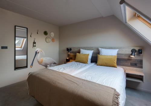 a bedroom with a large bed with yellow pillows at Prins Hendrik Texel in Oost