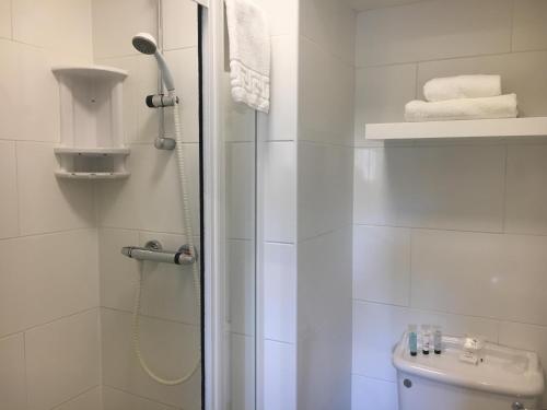 a white bathroom with a shower and a toilet at Hotel Balmoral in Bournemouth