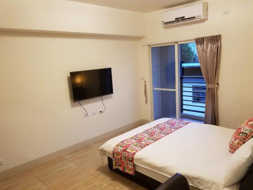 a bedroom with a bed and a flat screen tv at Especially chef's home B&B in Hualien City