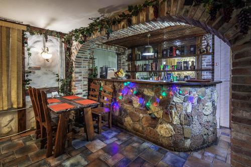 a bar with a stone wall and a table and chairs at Garden Hotel in Moscow