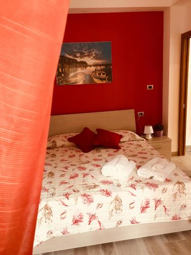 a bedroom with a bed with a red wall at La Pachira in Agropoli