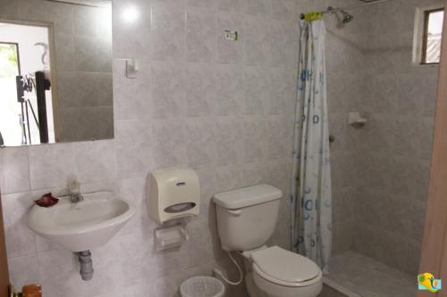a bathroom with a toilet and a sink and a shower at Hotel Campestre CENVATURS in Ricaurte