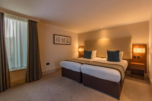 a hotel room with a large bed and a window at Thistle Trafalgar - Leicester Square in London