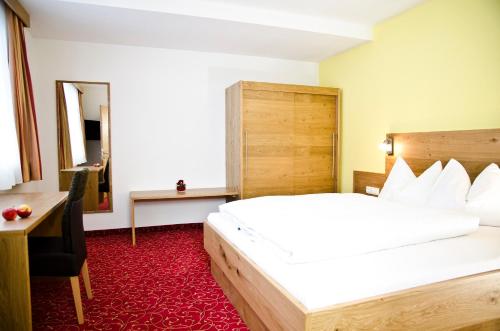 a bedroom with a large white bed and a desk at Chalet Barbara in Ischgl
