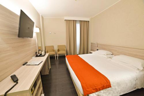 a hotel room with a bed and a desk with a television at Best Western Park Hotel in Piacenza