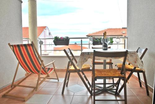 a table and chairs on a balcony with a view at Apartment Dalmatia in Makarska