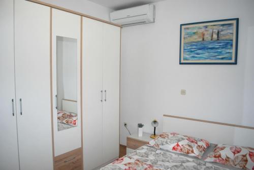 a bedroom with a bed and a white cabinet at Apartment Dalmatia in Makarska