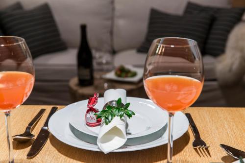 a table with a plate of food and two wine glasses at Chaty Zakopane in Zakopane