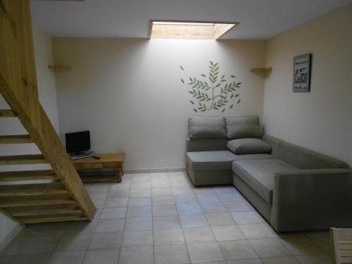 ein Wohnzimmer mit einem Sofa und einer Treppe in der Unterkunft gîte de Courcelette in Courcelette