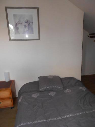 ein Bett in einem Schlafzimmer mit einem Bild an der Wand in der Unterkunft gîte de Courcelette in Courcelette