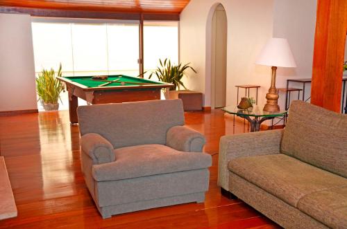 a living room with a couch and a pool table at Casa do Manequinho Hotel e Restaurante in Piraí