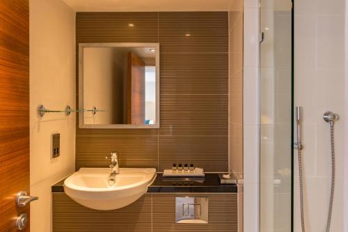 a bathroom with a sink and a shower at Thistle Trafalgar - Leicester Square in London