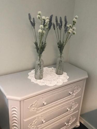 two vases with flowers on top of a dresser at Bergbach in Ramsau
