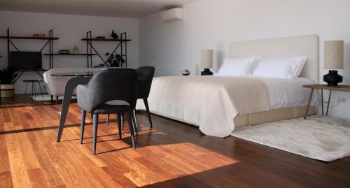 a bedroom with a bed and a table and chairs at Quinta Tagus in Costa da Caparica