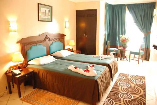 a bedroom with two dogs laying on a bed at New Farah Hotel in Agadir