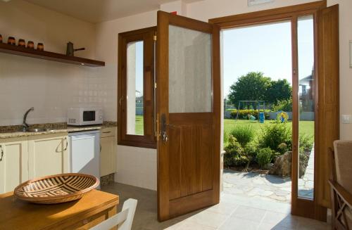a kitchen with a door leading to a garden at Apartamentos La Cruz de Paderne in Navia