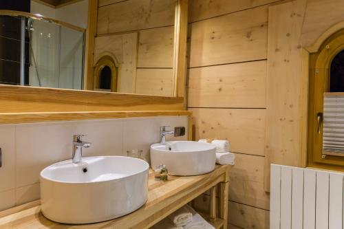 two sinks in a bathroom with wooden walls at Chaty Zakopane in Zakopane
