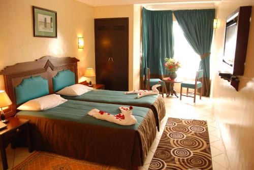 a hotel room with two beds with stuffed animals on them at New Farah Hotel in Agadir